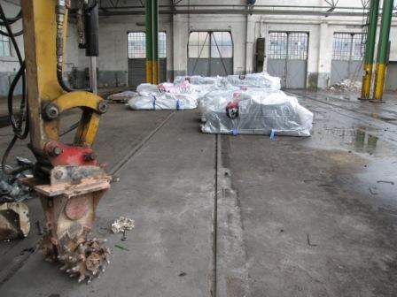 Sachgerechte Separierung von belastetem Beton (Fräsmaschine); 
im Hintergrund: verpackte Asbestplatten 